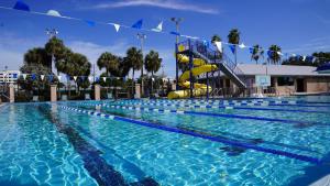 a swimming pool with a water slide in the background at Blue Wave Suites in Clearwater Beach