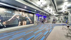Addison HeightsにあるModern Apt W Business Space & Gymのフィットネスルーム付きの大きな壁のジム