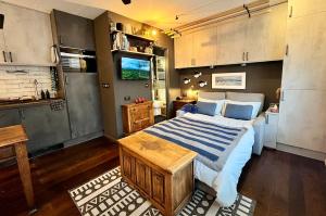 a bedroom with a large bed and a kitchen at Posh Studio Apartment Heart of Newlyn in Newlyn