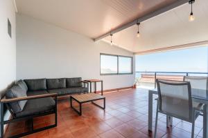 ein Wohnzimmer mit Sofa und Tisch in der Unterkunft Casa do Paulinhos in Estreito da Calheta