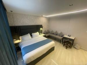 ワディ・ムーサにあるpetra night hostelの大きなベッドとソファのあるホテルの部屋