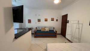 a living room with a couch and a flat screen tv at Surf House Mar Brasil in Ubatuba