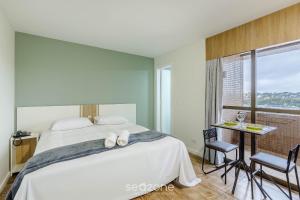 Un dormitorio con una cama y una mesa y sillas. en Estudios at Upper Residence - UPP, en Curitiba 114 fotos más