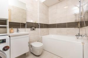 a bathroom with a tub and a toilet and a sink at Touch and Go Apartment near Bucharest Airport in Otopeni
