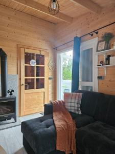 Una sala de estar con un sofá y una chimenea. en Lavendowa oaza, en Kocierz Rychwałdzki