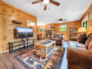 a living room with wooden walls and a flat screen tv at The Eagle's Nest Mountain Cabin Gatlinburg in Gatlinburg