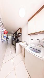 Vila BalneáriaにあるCantinho em Família - XF05Hの白いキッチン(洗濯機付)