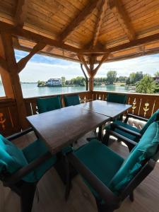 a wooden table and chairs on the deck of a boat at Niki Tóparti Pihenő in Gyékényes