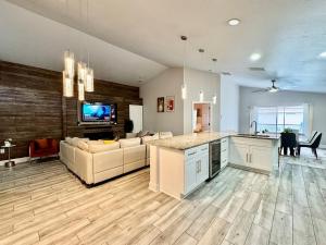 a kitchen and living room with a couch and a table at Modern 4BR 2BA with pool in gated community in Kissimmee