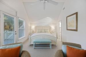 a white bedroom with a bed and two chairs at SM11: 11 Silver Moss in Kiawah Island +61 photos