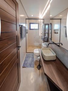 a bathroom with a toilet and a sink and a door at casa mantiqueira in Gonçalves