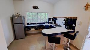 una cucina con frigorifero, tavolo e sedie di Casita del Arco El Cedral Cozumel a Cozumel