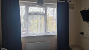 a window in a room with a blue curtain at Room Only Booking in Bedford