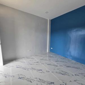 ein leerer Raum mit einer blauen Wand und Marmorboden in der Unterkunft M&S Cabina in Alburquerque