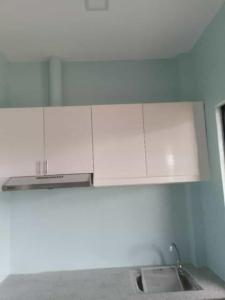 eine Küche mit weißen Schränken und einer Spüle in der Unterkunft M&S Cabina in Alburquerque