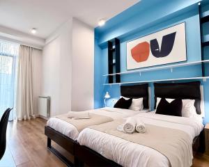 a bedroom with two beds and a blue wall at Vere Side Rooms in Tbilisi City