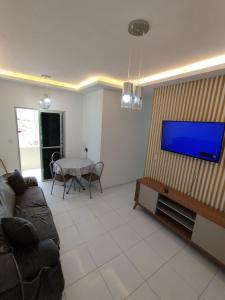 a living room with a couch and a flat screen tv at Apto Top Completo in Aracaju