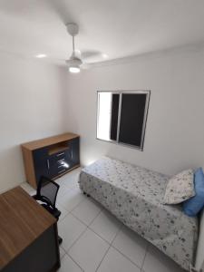 a small room with a bed and a television at Apto Top Completo in Aracaju