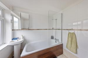 a white bathroom with a tub and a sink at Lesley House 4 bed villa TV Internet Garden in Gillingham +28 photos