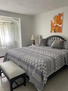 a bedroom with a large bed with a black and white blanket at Gem in Runaway Bay