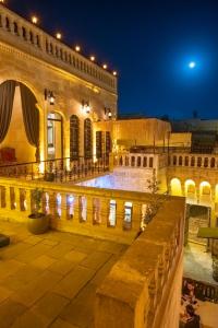 a large building with a courtyard at night at Turkmen Konagi in Urfa +23 photos
