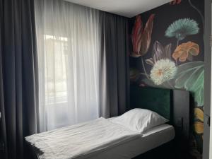 Una cama pequeña en una habitación con ventana. en Hotel Elsen, en Grevenbroich