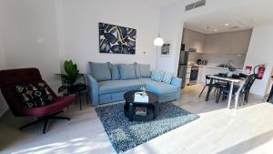a living room with a blue couch and a table at F1 - Camellia 1BR Waters Edge Yas Island, Theme Parks in Abu Dhabi