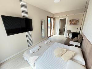 Un dormitorio con una cama con un televisor de pantalla plana en la pared. en La Suite N4 exclusive rooms, en Alghero