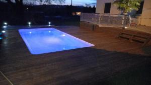 a blue swimming pool in a backyard at night at Studio privé tout équipé in Roquefort-sur-Garonne +8 photos