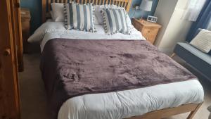 a bedroom with a large bed with a brown blanket at Room Only Booking in Bedford