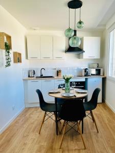 a kitchen with a table and chairs in a room at Appartement proche Ancenis - Loire et Vélo in Liré