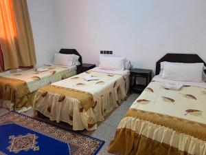 une chambre avec deux lits dans une pièce dans l'établissement COMPLEXE TOURISTIQUE ARTIZANAL bab sahara, à Oulad Akkou