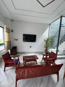 a room with four wooden chairs and a flat screen tv at Two-bedroom flat - River view, elevator, free inside car parking in Mỹ Phước