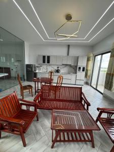 a living room with wooden benches and a kitchen at Two-bedroom flat - River view, elevator, free inside car parking in Mỹ Phước +7 photos