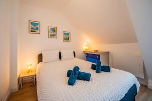 a bedroom with a bed with blue bows on it at La Pause Tourangelle - Calme - Wifi - Parking in Monnaie