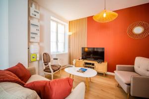 a living room with a couch and a tv at La Pause Tourangelle - Calme - Wifi - Parking in Monnaie
