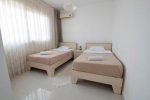 a bedroom with two beds and a window at Трехкомнатные апартаменты в жилом комплексе Caesar Beach D2 Flat16 in Boğaz +35 photos
