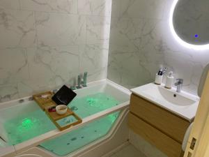 a bathroom with a bath tub and a sink at Évasion étoilée in Corbeil-Essonnes