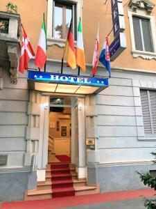 a hotel with flags on the front of a building at Hotel Aurelia Milano Centrale in Milan