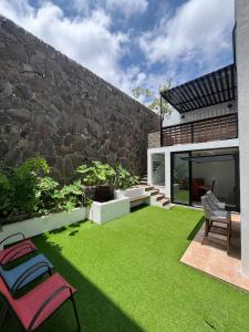 a backyard with green grass and a stone wall at BIG HOUSE, máximo 22 personas !!!!!!!!!!!!!!! in Guadalajara