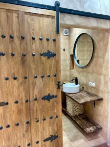 bagno con porta in legno, lavandino e specchio di 66 Dar Aarab - Marrakech a Marrakech Altre 51 foto