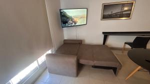 Una sala de estar con un sofá y un televisor en la pared. en HOUSE AND SUITE SF RIVADAVIA, en Santa Fe