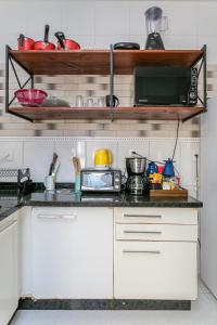 a kitchen with a counter top with a microwave at Casa perto do centro e da Udesc Cefid in Florianópolis +4 photos