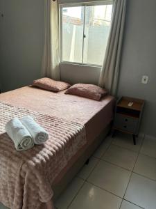 a bedroom with a bed with two towels on it at Spacious and comfortable apartment 2 in Oiapoque