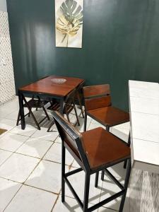 a table and chairs in a room with a green wall at Spacious and comfortable apartment 2 in Oiapoque