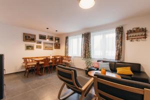 a living room with a couch and a table and chairs at Chalupa U Pastvišť in Stachy