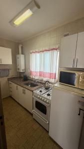 a kitchen with a stove and a refrigerator at MONOAMBIENTE muy cómodo a metros del mar in Mar del Plata