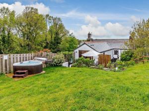 un patio trasero con una bañera de hidromasaje en el césped en 2 Bed in Fowey 76446, en Golant