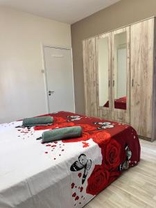 a bedroom with a bed with red flowers on it at Near Finikoudes Beach 15 in Larnaca