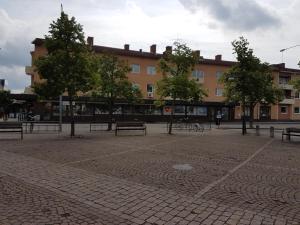 einem Park mit Bänken vor einem Gebäude in der Unterkunft Hultsfreds Vandrarhem in Hultsfred